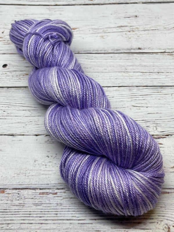A twisted skein of tonal light purple and white yarn. The yarn is 50% silk and 50% Superwash Merino wool.