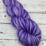 Thick yarn that is light purple with pops of dark purple and hints of blue.